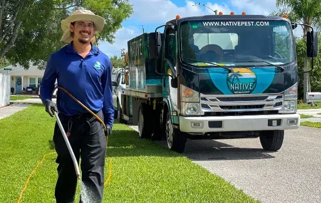 A technician spraying lawn with Native truck in the background